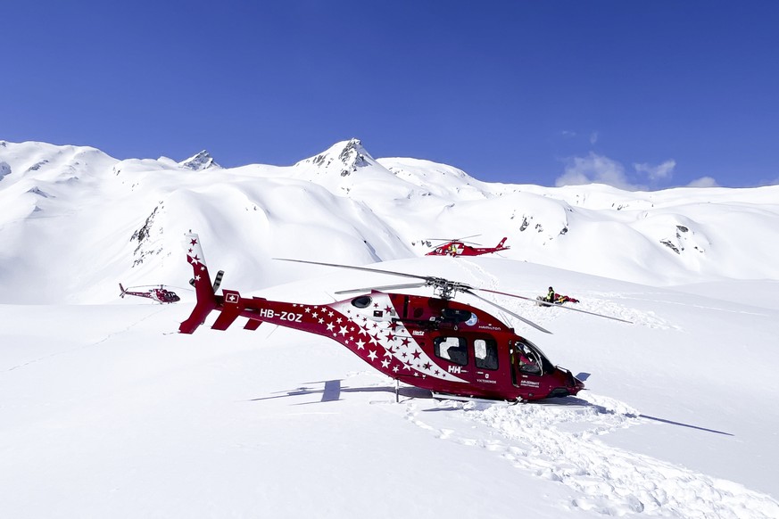 HANDOUT - Rescue helicopters stand on the mountain landing site of the Petit Combin summit in Valais, Switzerland, Tuesday, April 2, 2024. Three people lost their lives when a helicopter crashed on Tu ...