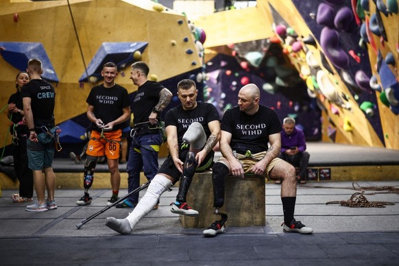 Former Ukrainian service members, who were injured in the war against Russia and now have prosthetic legs, take part in an indoor climbing session at Climbing SPACE in Kyiv on February 26, 2026, amid  ...