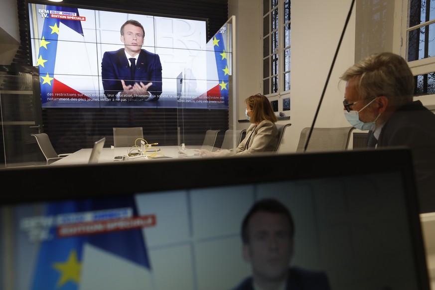 Local prefect Josiane Chevalier, second right, and her aide watch French President Emmanuel Macron addressing the nation, in the local government building in Strasbourg, eastern France, Wednesday, Mar ...