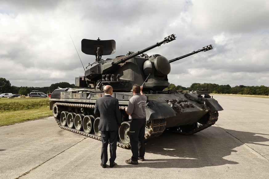 epa10137731 German Chancellor Olaf Scholz is shown an anti-aircraft gun tank Gepard, by Juergen Schoch the lead trainer for the Gebhard system, during his visit a training facility of the arms-maker K ...