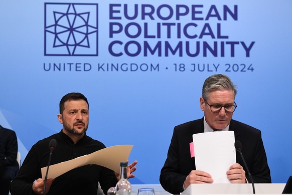 epa11485217 British Prime Minister Keir Starmer (R) and Ukrainian President Volodymyr Zelensky (L) attend the Opening Plenary at the European Political Community (EPC) meeting at Blenheim Palace, in W ...