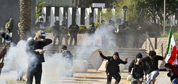 Protesters run from police as they use tear gas and flash-bangs at the Federal Building in Santa Ana, Calif., on Monday, June 9, 2025. (Jeff Gritchen/The Orange County Register via AP)
Immigration Rai ...