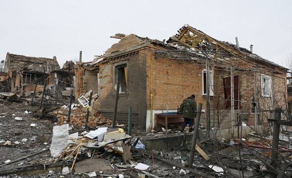 epa11101443 A local man walks past debris of a damaged private building on the site of a missile attack in Kharkiv, northeastern Ukraine, 24 January 2024, amid the Russian invasion. At least ten perso ...