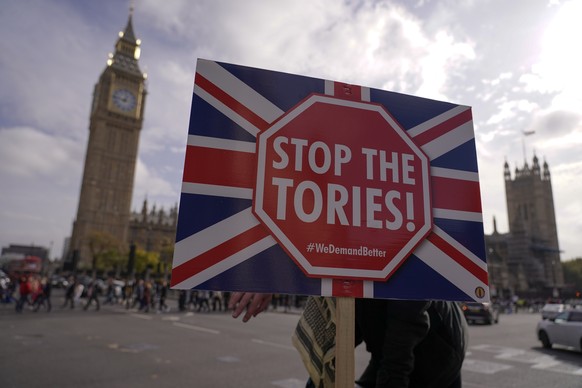 A placard saying &quot;Stop the Tories&quot; is held by a demonstrator outside the Houses of Parliament, in London, Wednesday, Oct. 19, 2022. Since the shock 2016 referendum vote to leave the European ...