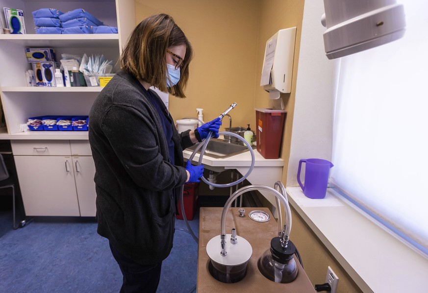 Lab assistant Sydni Hanson prepares a suction machine for use between appointments, Thursday, July 7, 2022, at WE Health Clinic in Duluth, Minn. (AP Photo/Derek Montgomery)