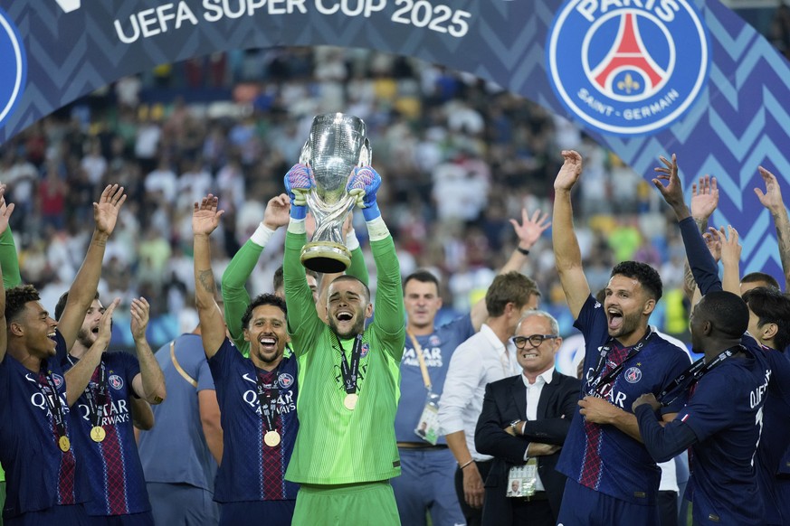 PSG players celebrate with the trophy after winning the UEFA Super Cup soccer match between Paris Saint-Germain and Tottenham Hotspur in Udine, Italy, Wednesday, Aug. 13, 2025. (AP Photo/Darko Bandic) ...