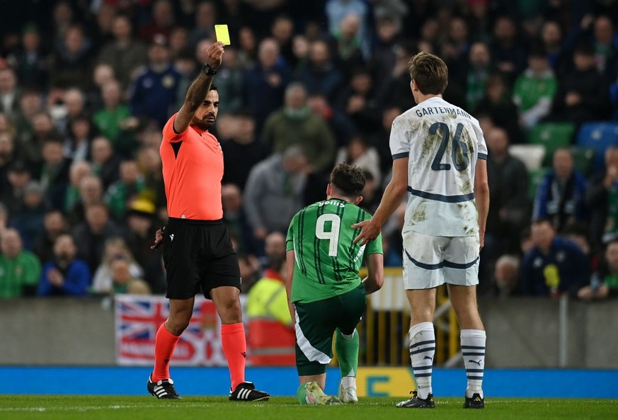 BELFAST, NORTHERN IRELAND - MARCH 21: Referee Mohammed Al-Hakim shows a yellow card to Stefan Gartenmann of Switzerland during the International Friendly match between Northern Ireland and Switzerland ...