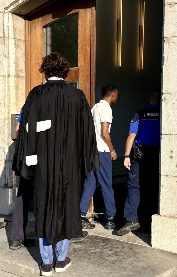Entrée de l'accusé, menotté, au tribunal en présence de gendarmes, sous le regard de son avocat.
