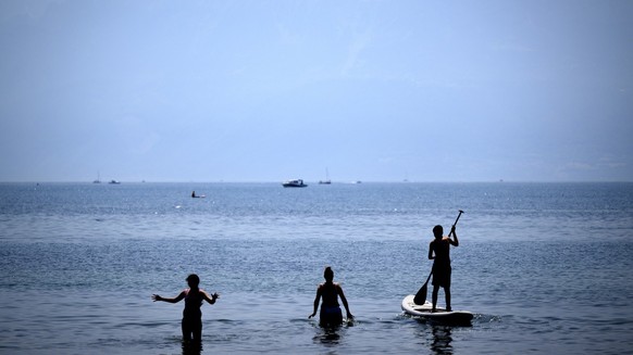 People cooling off in the Lake Geneva at the Vidy beach (plage de Vidy) in Lausanne, Switzerland, Sunday, June 19, 2022. People flocked to parks and pools across Western Europe on Sunday for a bit of  ...