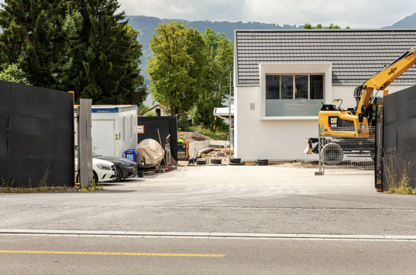 Les ouvriers travaillent toujours sur le chantier. Des pelleteuses et des conteneurs sont installés à l'entrée.