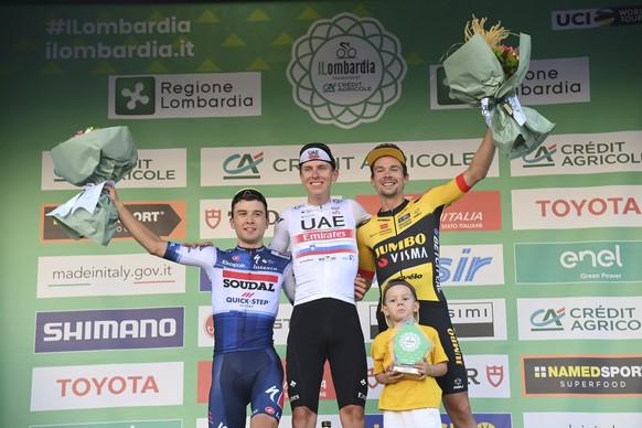 Winner Tadej Pogacar celebrates on podium with second placed Andrea Bagioli, left, and third placed Primoz Roglic, right, after the tour of Lombardy cycling race, from Como to Bergamo, Italy, Saturday ...