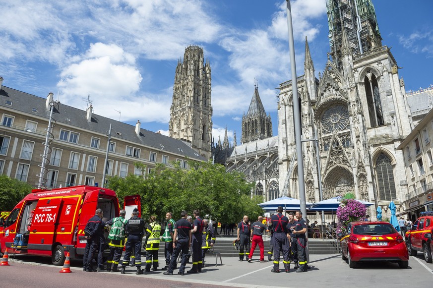 epa11472481 Firefighters stand outside the cathedral in Rouen, France, 11 June 2024. The spire of the Cathedral caught fire, Mayor Mayer-Rossignol announced on X. The fire started on the construction  ...