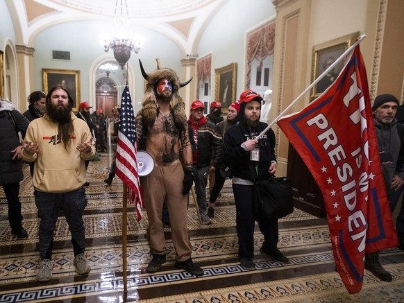 epa08923457 Supporters of US President Donald J. Trump stand by the door to the Senate chambers after they breached the US Capitol security in Washington, DC, USA, 06 January 2021. Protesters stormed  ...