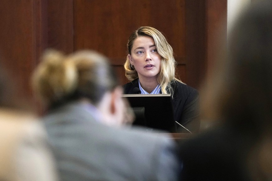 Actor Johnny Depp, left, listens as actor Amber Heard testifies in the courtroom at the Fairfax County Circuit Court in Fairfax, Va., Wednesday May 4, 2022. Depp sued his ex-wife Heard for libel in Fa ...