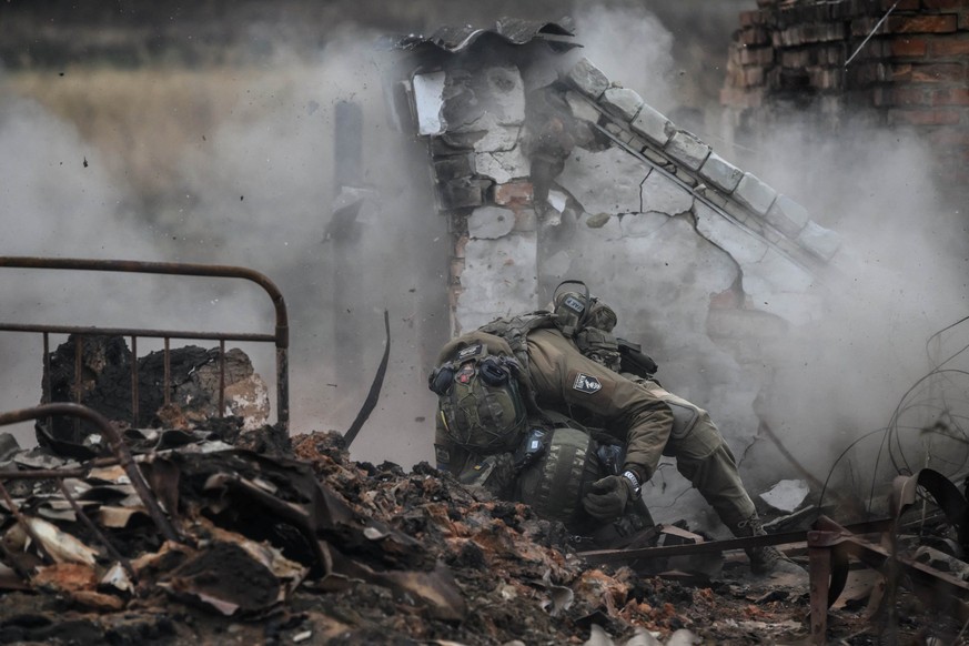 (FILES) Infantry recruits of the 28th Seperate Mechanized Brigade take cover from a grenade blast as they undergo a basic training course at an undislosed location in eastern Ukraine on October 9, 202 ...