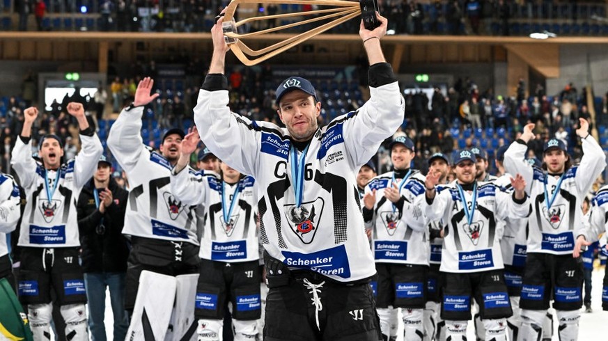 DAVOS, SWITZERLAND - DECEMBER 31: Julien Sprunger of HC Fribourg-Gotteron raises the trophy after winning the Spengler Cup Davos final match between Straubing Tigers and Fribourg-Gottéron at Eisstadio ...