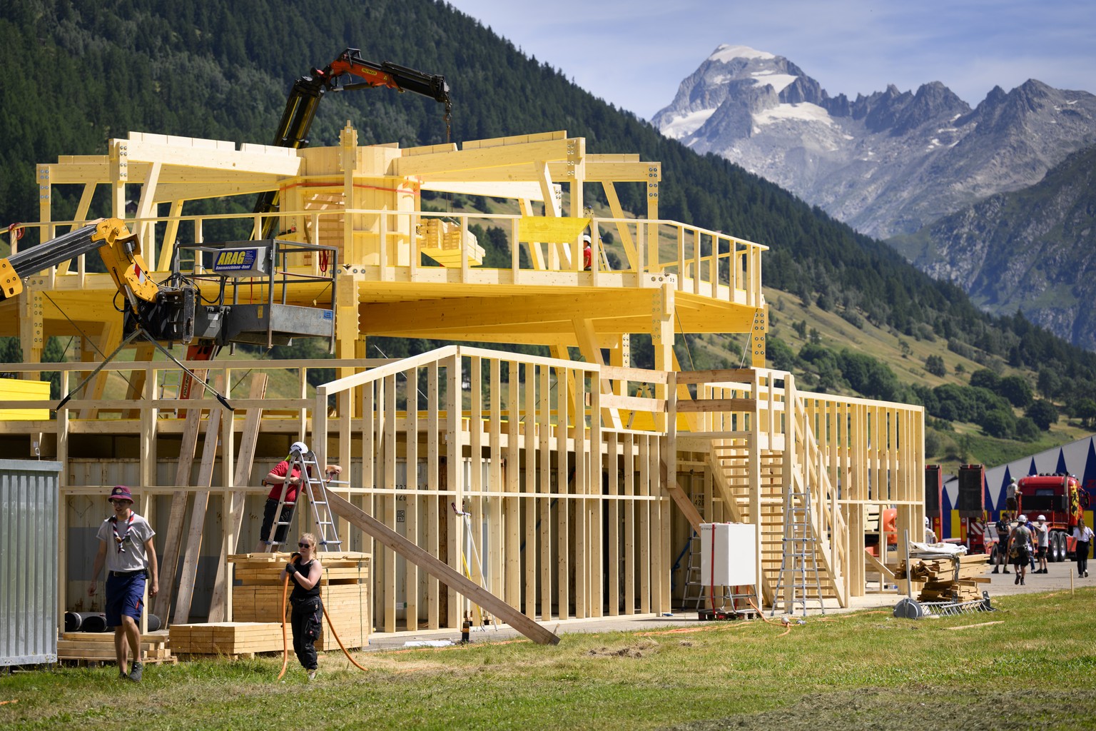 Des ouvriers montent un batiment en bois lors de la construction des infrastructures du Camp federal Scouts, mova, ce jeudi 14 juillet 2022 a la Vallee de Conches a Ulrichen sur la commune de Goms. Le ...