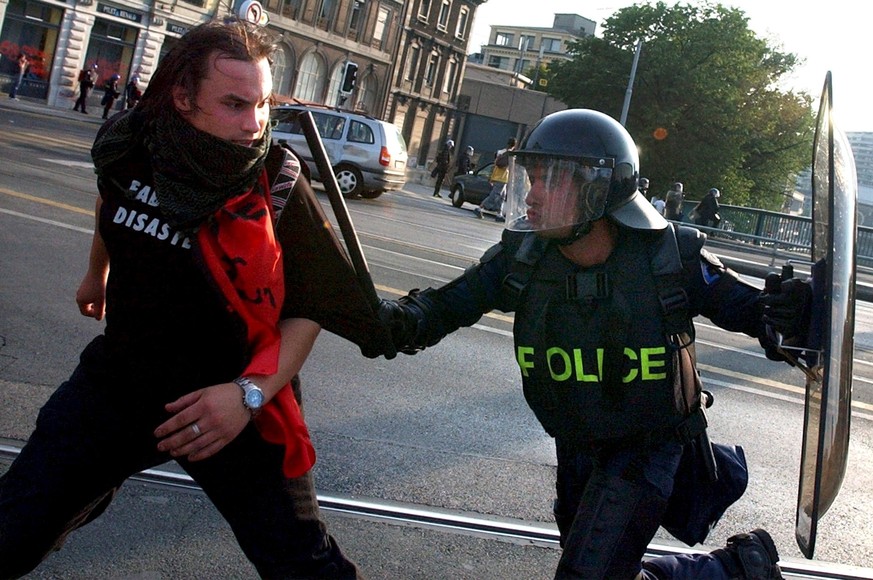 A police officer arrests a rioting demonstrator Sunday, June 1, 2003 in the streets of Geneva, Switzerland. After heavy riots Saturday night and Sunday morning, demonstrators continued to show their d ...