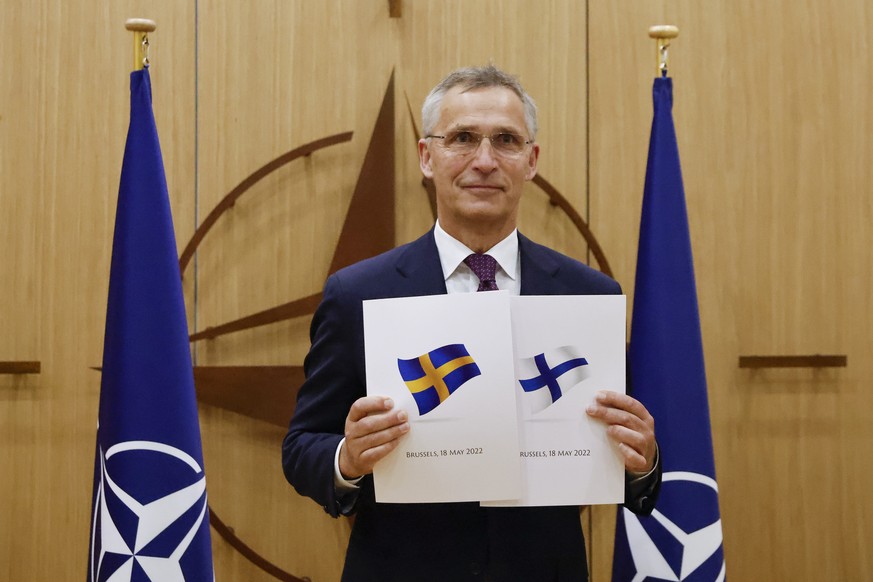 FILE - NATO Secretary-General Jens Stoltenberg displays documents as Sweden and Finland applied for membership in Brussels, Belgium, May 18, 2022. Delegations from Sweden and Finland were expected in  ...