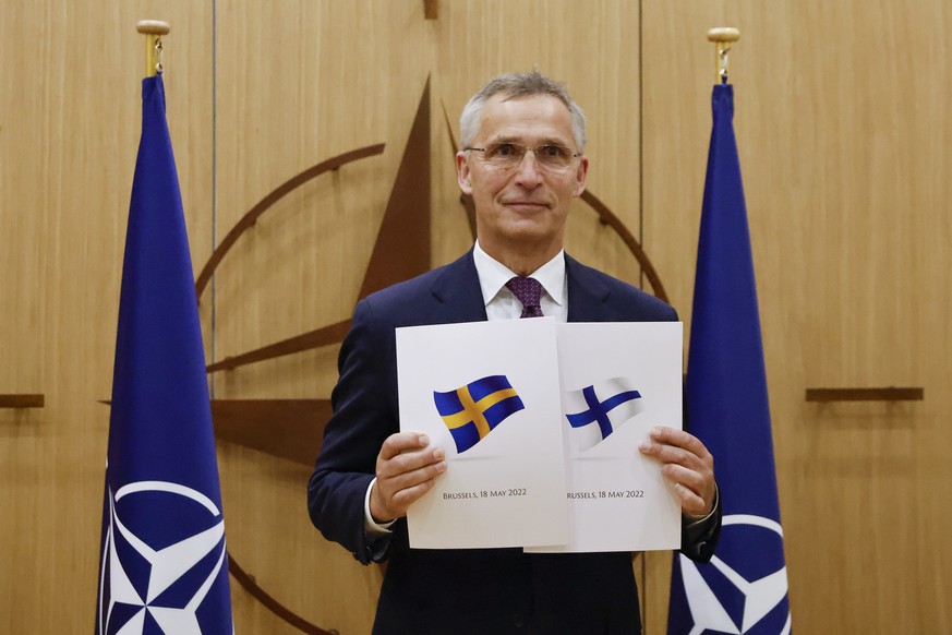 FILE - NATO Secretary-General Jens Stoltenberg displays documents as Sweden and Finland applied for membership in Brussels, Belgium, May 18, 2022. Delegations from Sweden and Finland were expected in ...