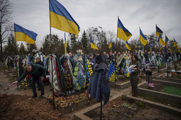 People line up to throw dirt in the grave during the farewell for Ukrainian Cpt. Serhii Vatsko in Boiarka, Ukraine, Friday, March 29, 2024. Vatsko, who was killed on the frontline of eastern Ukraine o ...