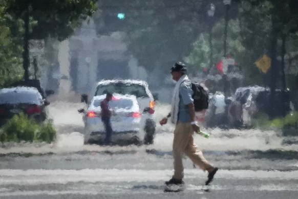 FILE - A person crosses Caroline Street in the afternoon heat Saturday, May 25, 2024, near Discovery Green in Downtown Houston. The death certificates of more than 2,300 people who died in the United  ...