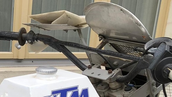 En haut à gauche de la KTM en 1983, le support recevant les feuilles dont les motards se débarrassaient.