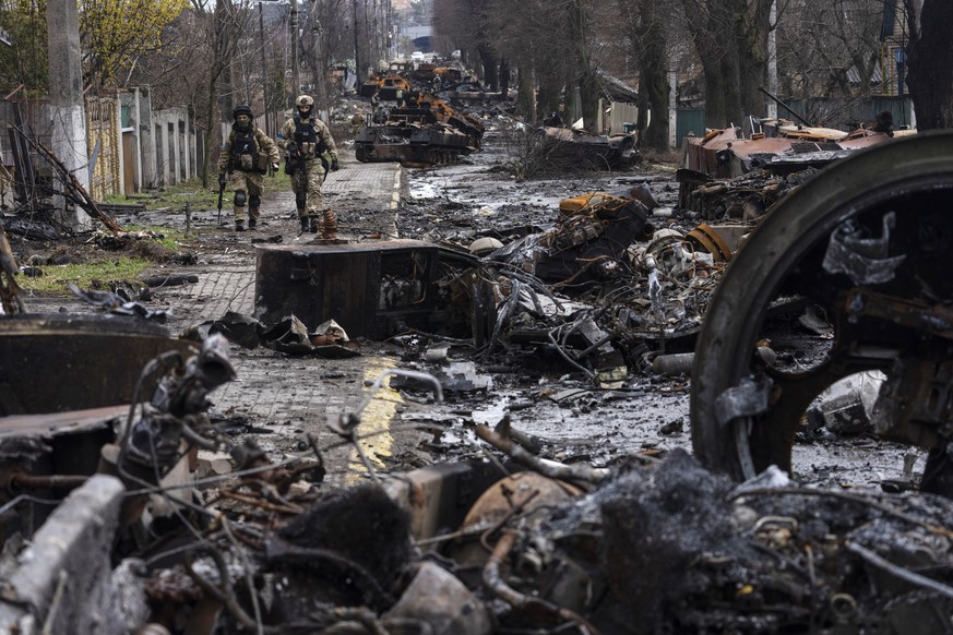 FILE - Soldiers walk amid destroyed Russian tanks in Bucha, on the outskirts of Kyiv, Ukraine, April 3, 2022. Kyiv was a Russian defeat for the ages. It started poorly for the invaders and went downhi ...
