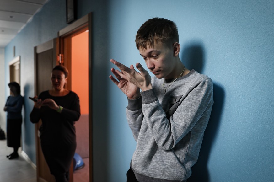 epa10483952 A resident of the project &#039;House of Special People&#039; pictures standing in an aisle in Puchkovo village outside Moscow, Russia, 22 February 2023. The &#039;House of Special People& ...