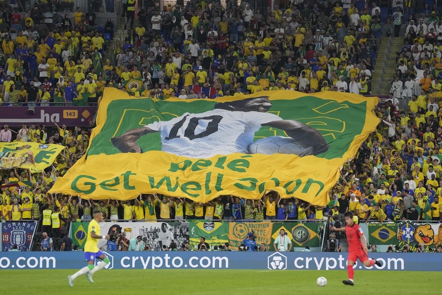Brazilian fans hold a banner showing the Brazilian soccer legend Pele with the message 'Get well soon' during the World Cup round of 16 soccer match between Brazil and South Korea at the Stadium 974 i ...
