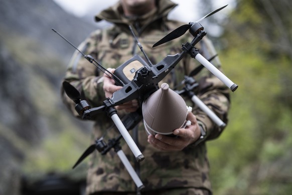 Ein Soldat zeigt eine Angriffsdrohne an einem Medienanlass der Schweizer Armee zur Einbindung von Drohnen in Kampfverbaende, am Montag, 18. Mai 2026, auf dem Schiessplatz Wichlen in Elm. (KEYSTONE/Gia ...