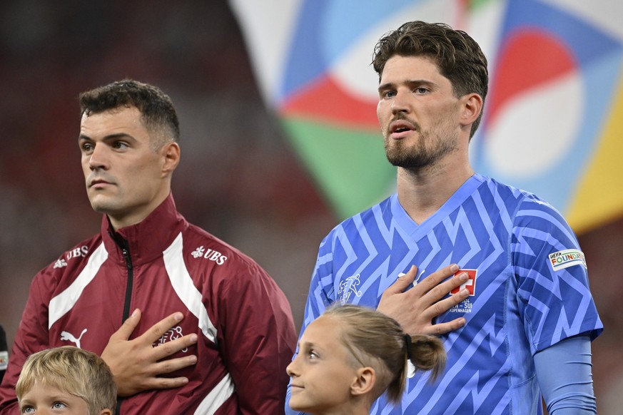 Switzerland's Granit Xhaka, left, and goalkeeper Gregor Kobel sing the national anthem during the UEFA Nations League Group D leg 1 soccer match between Denmark and Switzerland, on Thursday, Sept ...