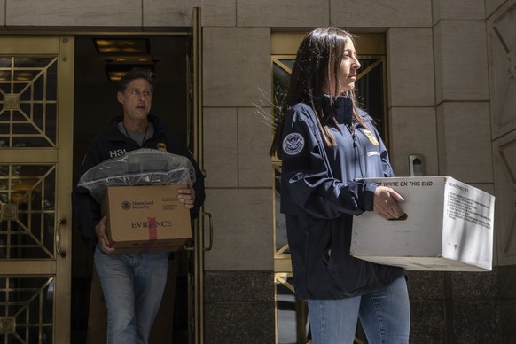 Federal agents carrying evidence boxes walk out of a Park Avenue high-rise on Thursday, Sep. 1, 2022, in New York. FBI agents and Homeland Security Investigations personnel searched properties linked  ...