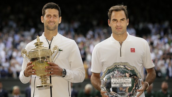 FILE - Serbia&#039;s Novak Djokovic, left, and Switzerland&#039;s Roger Federer pose with the trophies after the men&#039;s singles final match of the Wimbledon Tennis Championships in London, in this ...