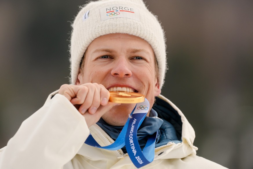 Johannes Hoesflot Klaebo, of Norway, poses after winning the gold medal on the podium of the cross-country skiing men's sprint classic at the 2026 Winter Olympics, in Tesero, Italy, Tuesday, Feb. ...