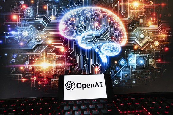 The OpenAI logo is displayed on a cell phone with an image on a computer monitor generated by ChatGPT&#039;s Dall-E text-to-image model, Friday, Dec. 8, 2023, in Boston. Europe&#039;s yearslong effort ...