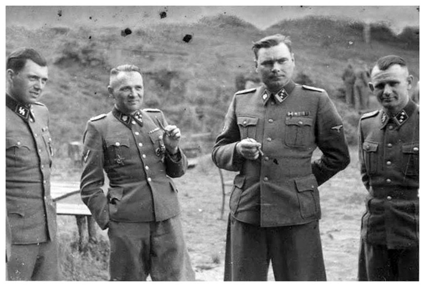 Des officiers de la SS pris en photo devant Auschwitz. Mengele est le premier depuis la gauche.