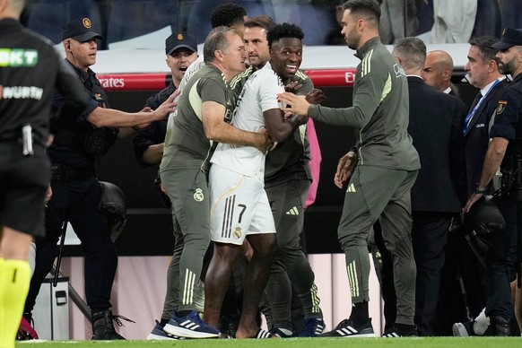 Real Madrid&#039;s Vinicius Junior is restrained by coaching staff duringa post match scuffle at La Liga soccer match between Real Madrid and Barcelona in Madrid, Spain, Sunday, Oct. 26, 2025. (AP Pho ...