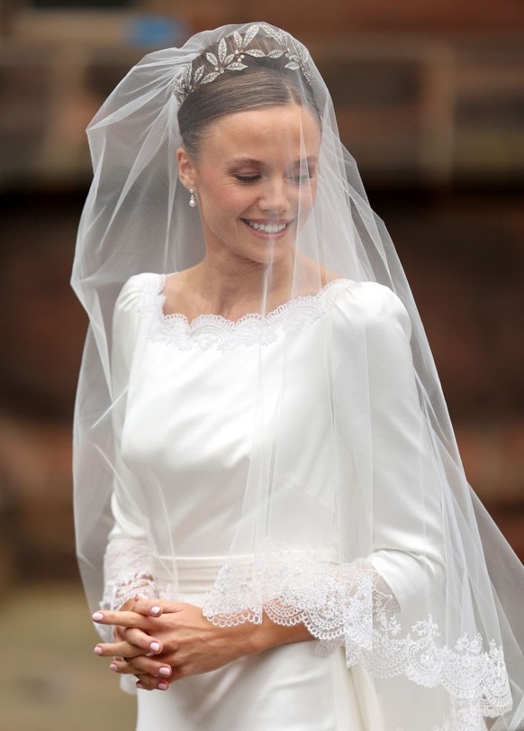 CHESTER, ENGLAND - JUNE 07: Olivia Henson smiles as she arrives for her wedding to Hugh Grosvenor, Duke of Westminster at Chester Cathedral on June 07, 2024 in Chester, England. (Photo by Chris Jackso ...