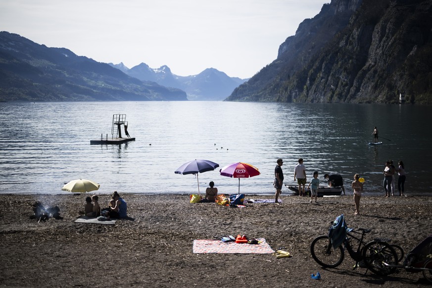 epa11262484 People visit the Walensee (Lake Walen) on a sunny spring day in Walenstadt, Switzerland, 06 April 2024. EPA/GIAN EHRENZELLER