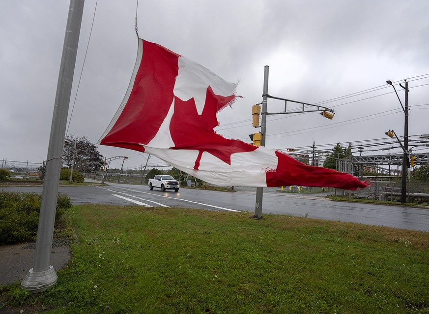 A Canadian flag waves in the high winds in Dartmouth, N.S. on Saturday, Sept. 24, 2022. Strong rains and winds lashed the Atlantic Canada region as Fiona closed in early Saturday as a big, powerful po ...