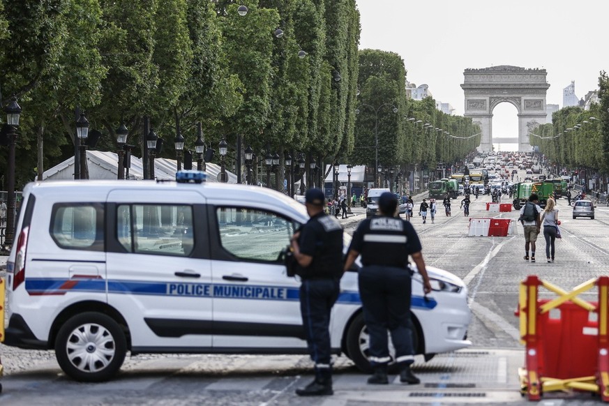 epa10722961 French police officers stand guard near the Arc de Triomphe, after five consecutive nights of riots across the country following the death of Nahel, who was killed by French Police, in Par ...
