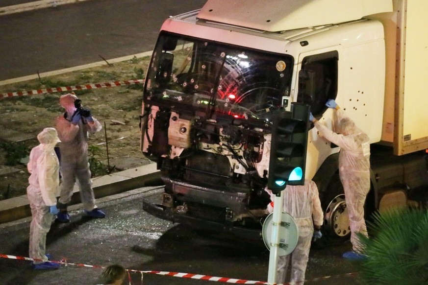 Authorities investigate a truck after it plowed through Bastille Day revelers in the French resort city of Nice, France, Thursday, July 14, 2016. France was ravaged by its third attack in two years wh ...