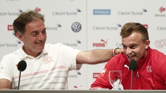 Switzerland&#039;s Xherdan Shaqiri, right, and Swiss assistant coach Michel Pont, left, talk to journalists during a media conference of the Swiss national soccer team in Porto Seguro, Brazil, Friday, ...