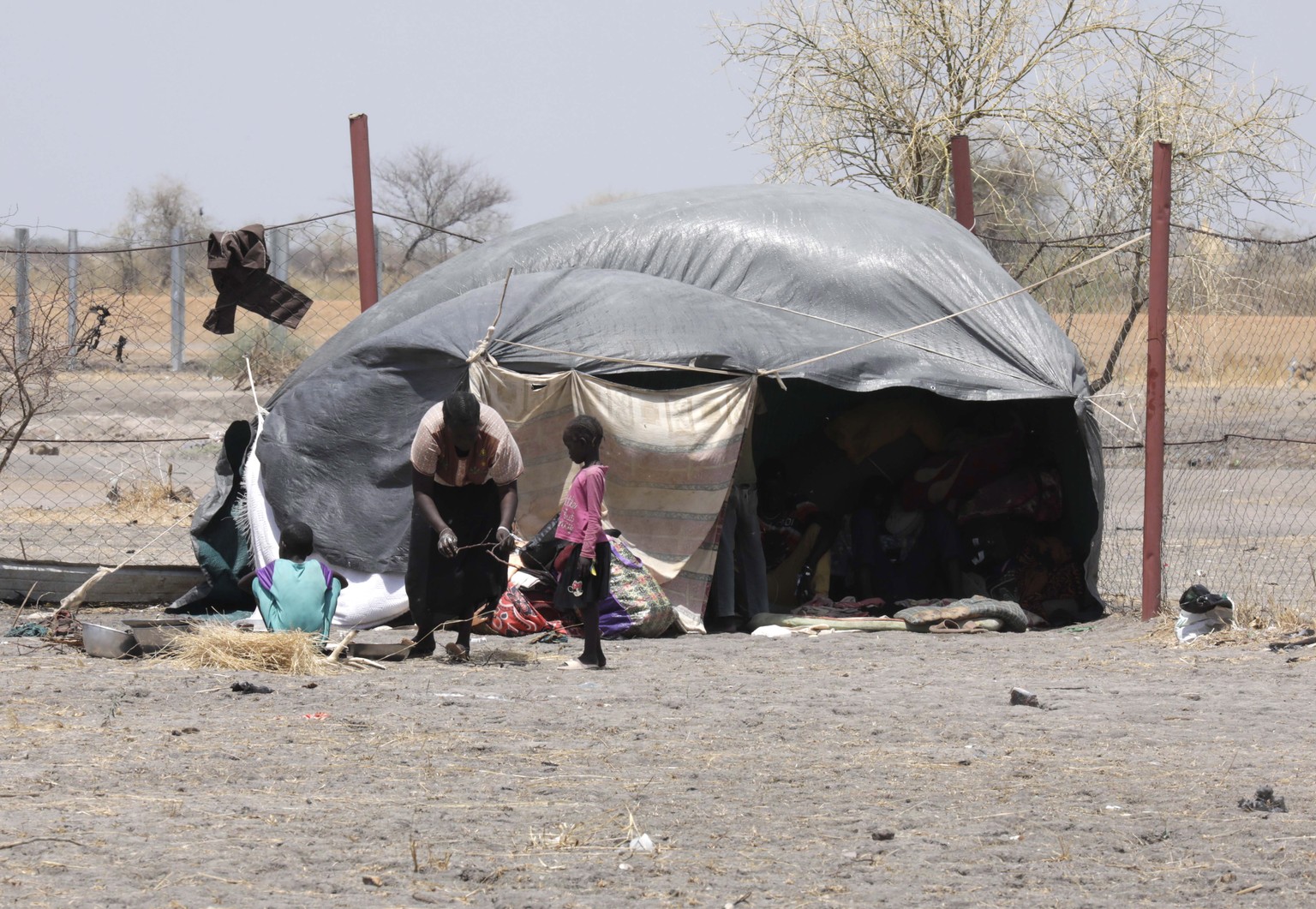 epa10628086 A South Sudanese returnee gathers wood for cooking next to her makeshift shelter, outside the Orthodox Church in the Upper Nile State town of Renk, South Sudan, 14 May 2023. The grounds of ...