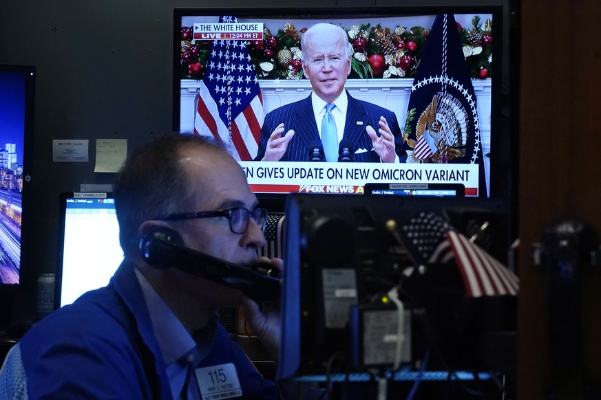 President Jose Biden appears on a screen as trader Mark Puetzer works on the floor of the New York Stock Exchange, Monday, Nov. 29, 2021. President Joe Biden urged Americans to get vaccinated includin ...