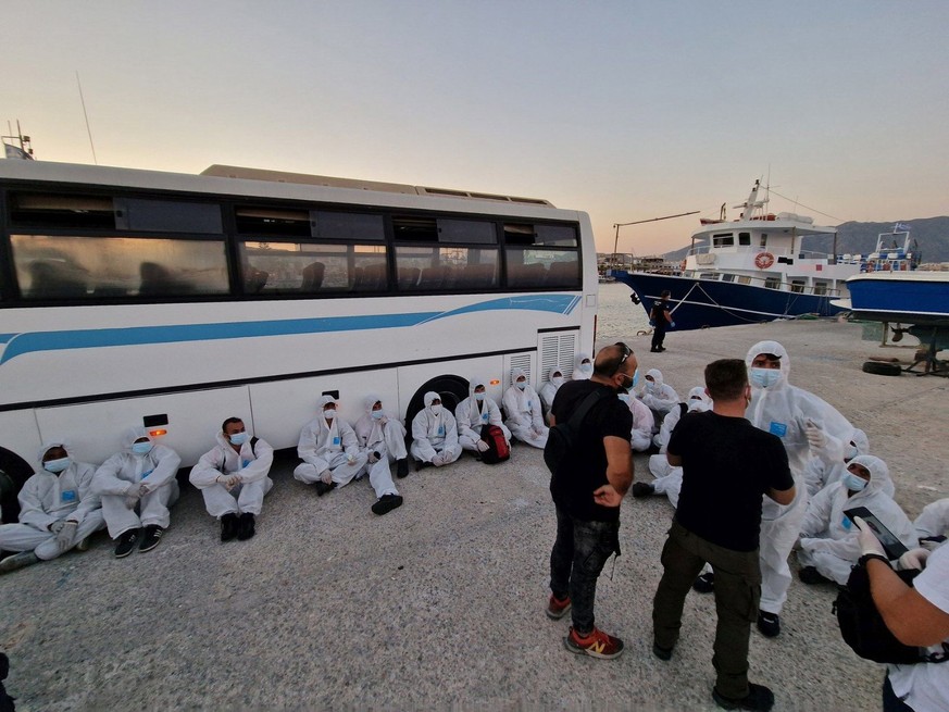 epa10114748 A handout photo made available by the Hellenic Coast Guard showing 27 migrants, rescued by a greek tanker, disembark from a vessel of Hellenic Coast Guard in the port of Kardamena, Kos Isl ...
