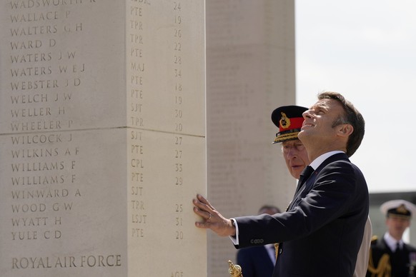 French President Emmanuel Macron and Britain's King Charles III look at engravings as they attend the UK's national commemorative event for the 80th anniversary of D-Day in Ver-sur-Mer, Fran ...