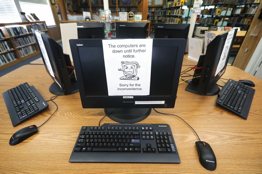 FILE - In this Aug. 22, 2019, file photo, signs on a bank of computers tell visitors that the machines are not working at the public library in Wilmer, Texas. The Associated Press has learned new deta ...