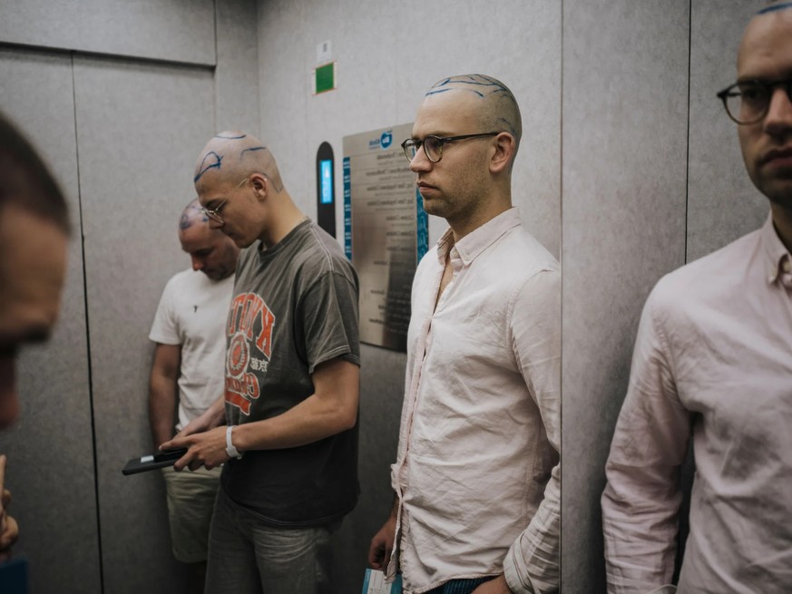 Les patients (au premier plan, Felix Hofmann) se rendent à l&#039;intervention dans l&#039;ascenseur.